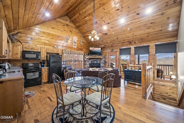 dining area with light wood-style floors, wooden ceiling, and wooden walls