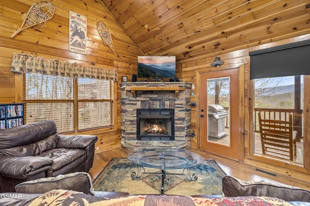 living area featuring wooden walls, lofted ceiling, and visible vents