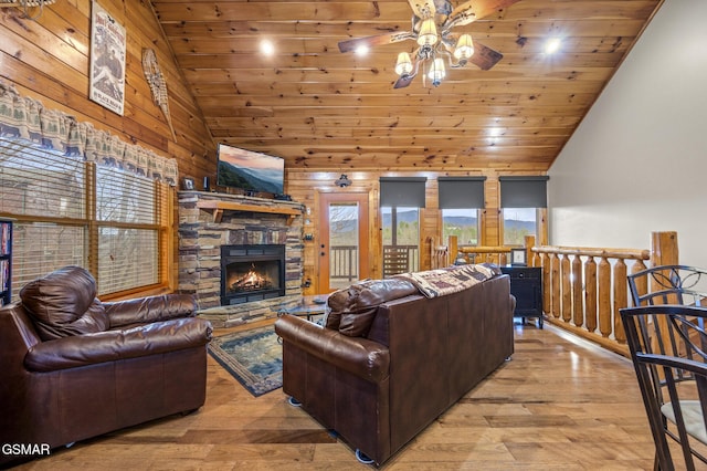 living room featuring ceiling fan, light wood-type flooring, wood ceiling, and a fireplace