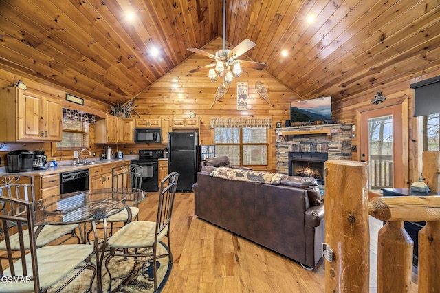 living area featuring wood walls, a stone fireplace, wooden ceiling, and a ceiling fan
