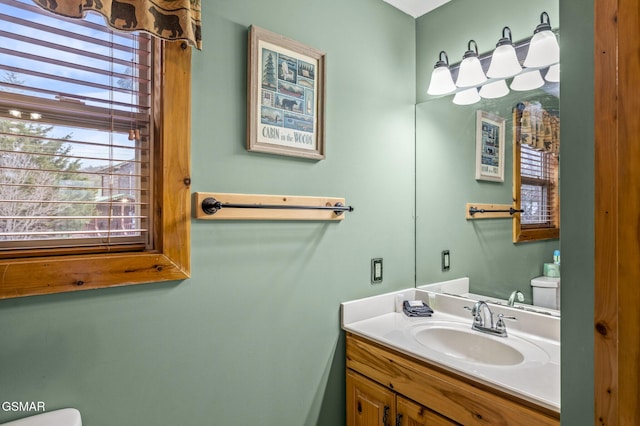 half bath featuring vanity and toilet