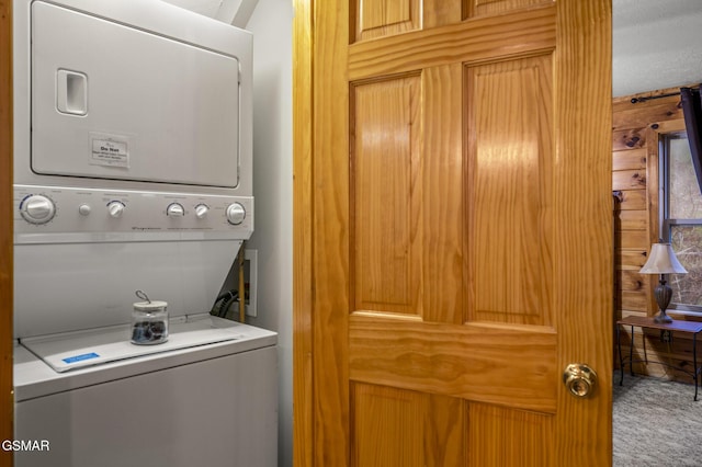 laundry room featuring stacked washer and dryer, carpet floors, and laundry area