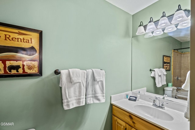 bathroom with toilet, a shower, and vanity