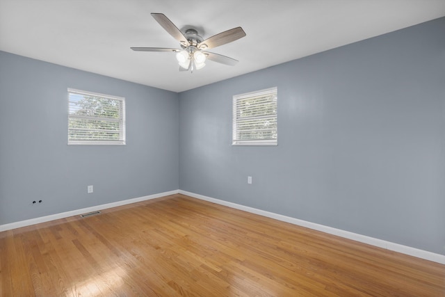 empty room featuring ceiling fan, plenty of natural light, and light hardwood / wood-style floors