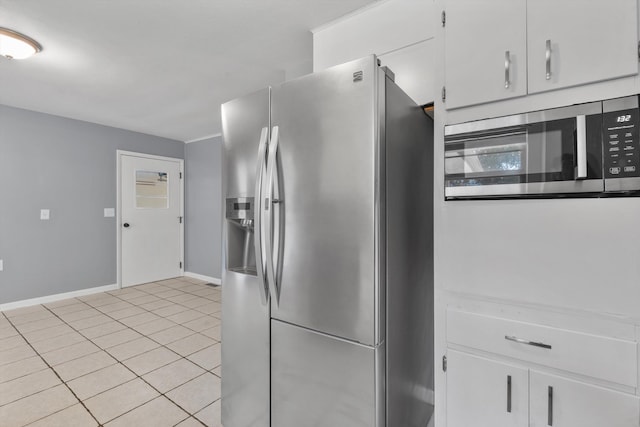 kitchen with light tile patterned flooring, white cabinetry, and stainless steel appliances