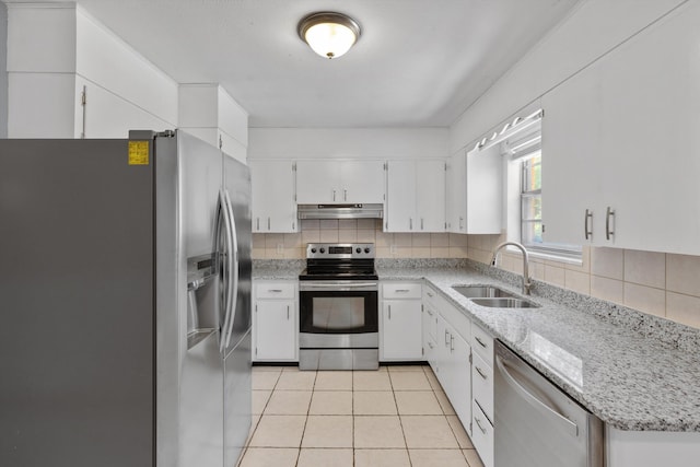 kitchen with light stone countertops, appliances with stainless steel finishes, backsplash, sink, and white cabinets