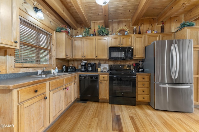 kitchen with sink, black appliances, light hardwood / wood-style flooring, beamed ceiling, and wood walls