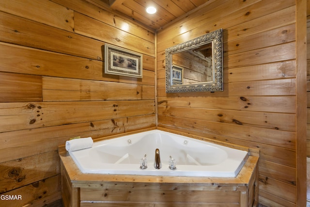 bathroom featuring a tub and wood walls