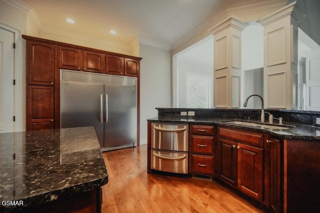 118 Luxury Ln, Dandridge, TN 37725 - kitchen featuring stainless steel appliances, crown molding, a sink, dark brown cabinets, and light wood finished floors