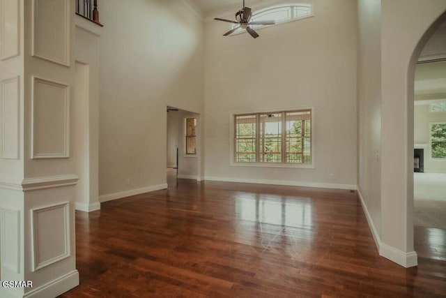 118 Luxury Ln, Dandridge, TN 37725 - unfurnished living room featuring arched walkways, ceiling fan, healthy amount of natural light, wood finished floors, and a towering ceiling