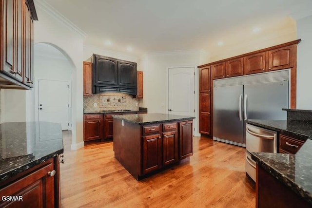 118 Luxury Ln, Dandridge, TN 37725 - kitchen featuring stainless steel appliances, light wood finished floors, backsplash, dark stone countertops, and ornamental molding