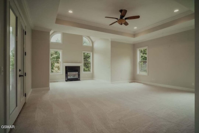 118 Luxury Ln, Dandridge, TN 37725 - unfurnished living room featuring a tray ceiling, a glass covered fireplace, carpet, ornamental molding, and baseboards