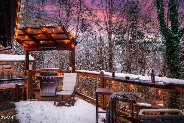 snow covered deck with a grill