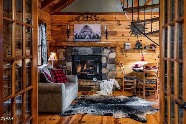 living area with wooden walls, wood finished floors, and a fireplace