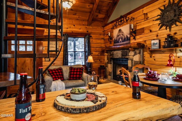 living area with wooden walls, wooden ceiling, lofted ceiling with beams, and a fireplace