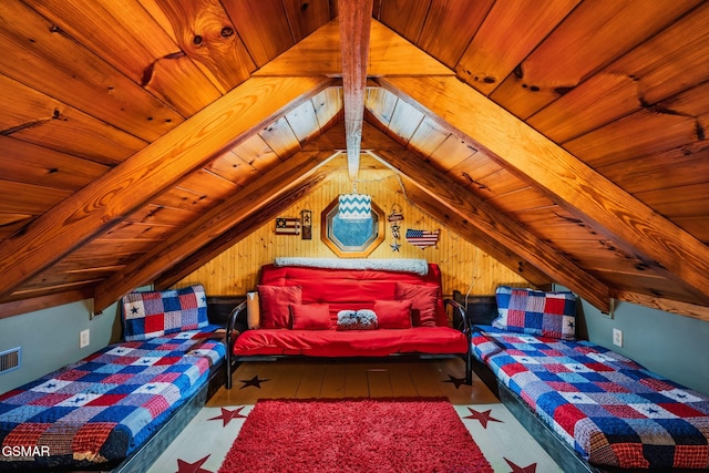 bedroom featuring lofted ceiling with beams, visible vents, hardwood / wood-style floors, wood ceiling, and wooden walls