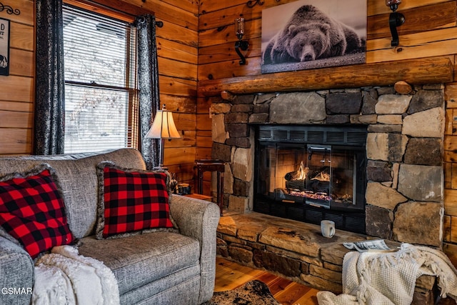 living room featuring a fireplace, wooden walls, and wood finished floors
