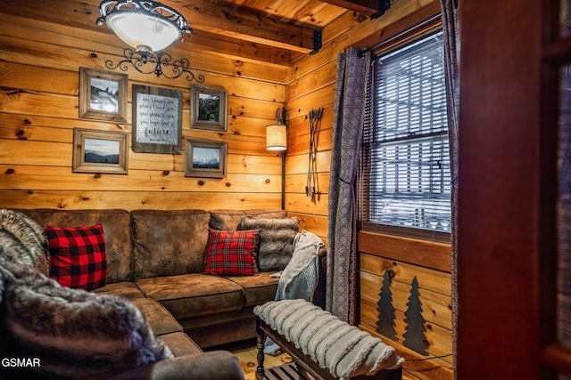 living area featuring wooden walls and beam ceiling