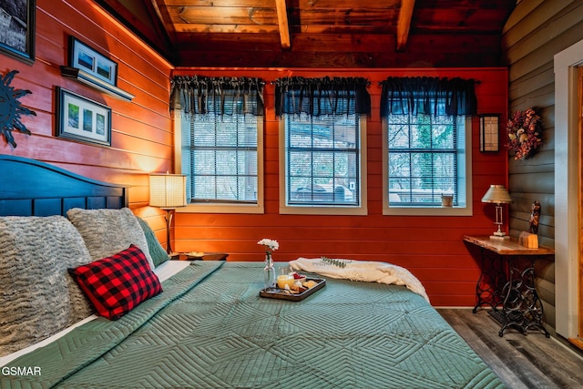 bedroom with wood walls, wood finished floors, and lofted ceiling with beams