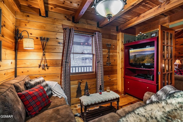 living room with wood walls, wooden ceiling, beam ceiling, and wood finished floors