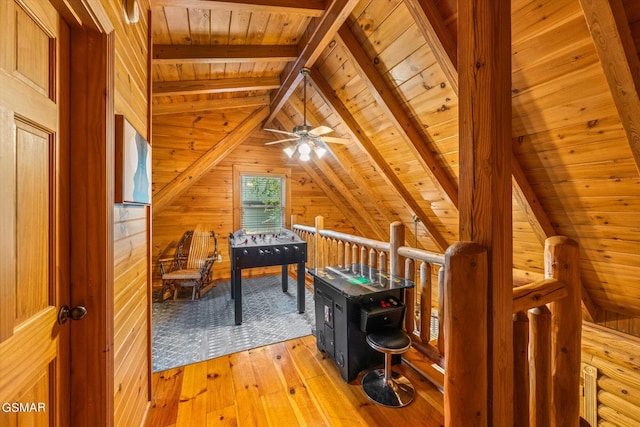 recreation room featuring wooden walls, ceiling fan, wood ceiling, and light wood-type flooring