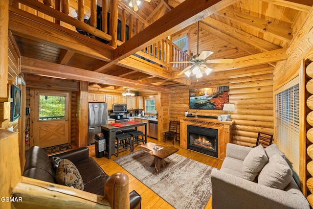 living room featuring beam ceiling, ceiling fan, log walls, and wood ceiling