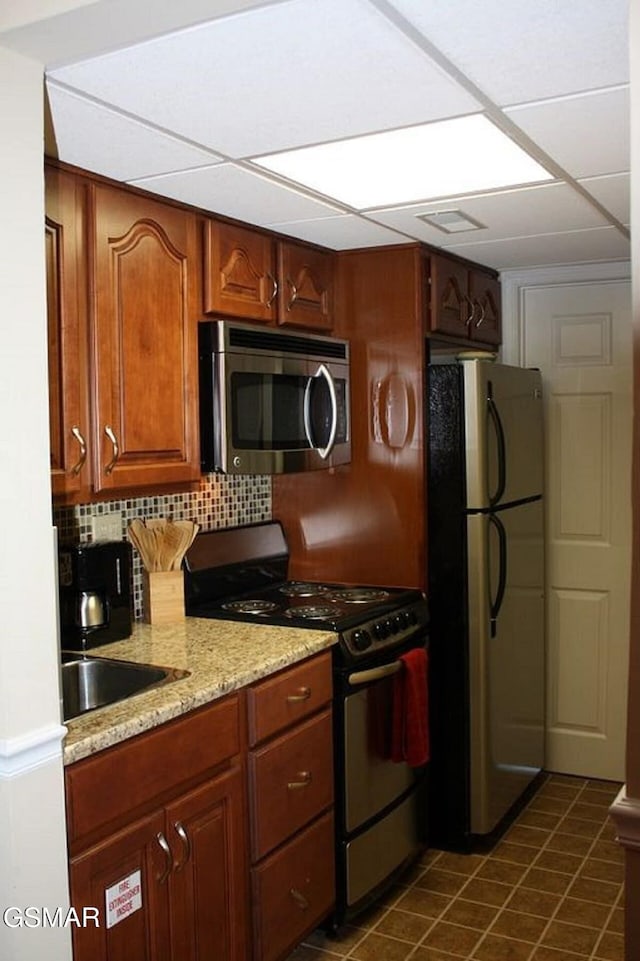 kitchen featuring stainless steel appliances, a paneled ceiling, tasteful backsplash, visible vents, and a sink