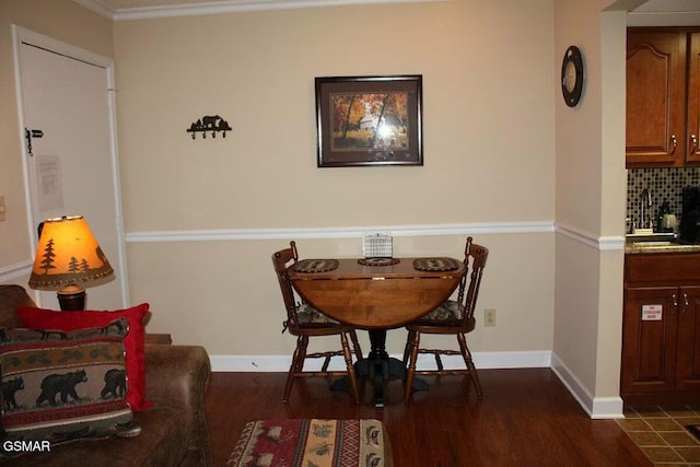dining area featuring dark wood-style floors, baseboards, and crown molding