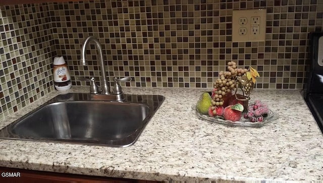 room details featuring tasteful backsplash and a sink