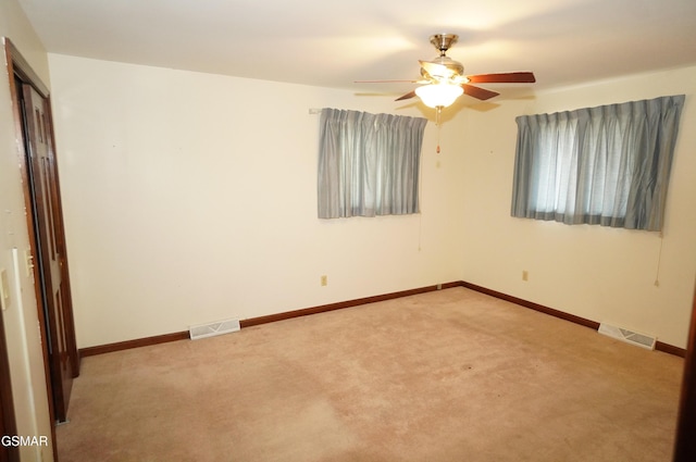 spare room featuring light carpet and ceiling fan