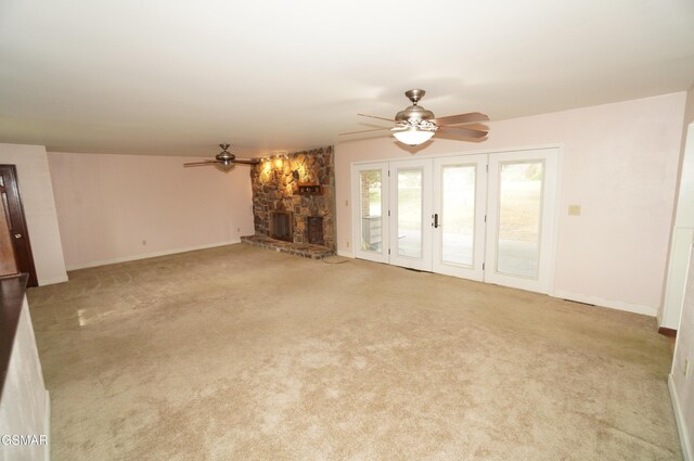 unfurnished living room with light carpet, a fireplace, and ceiling fan