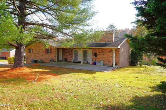 rear view of house featuring a lawn and a patio area