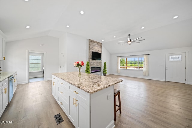 412 Apple Valley Rd, Sevierville, TN 37862 - kitchen with lofted ceiling, a stone fireplace, healthy amount of natural light, ceiling fan, and a center island