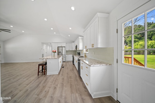 412 Apple Valley Rd, Sevierville, TN 37862 - kitchen featuring a kitchen breakfast bar, stainless steel appliances, white cabinets, tasteful backsplash, and lofted ceiling