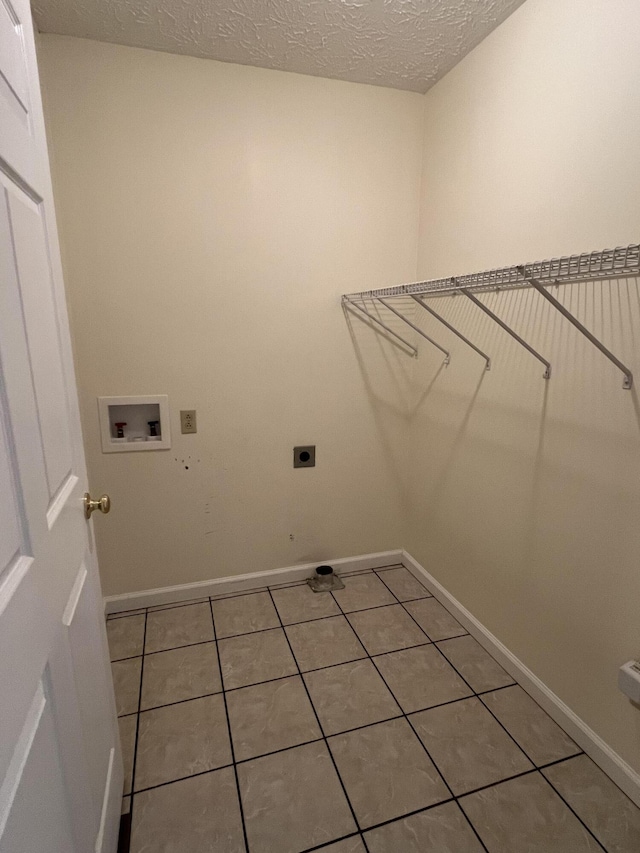 washroom with washer hookup, hookup for an electric dryer, tile patterned floors, and a textured ceiling