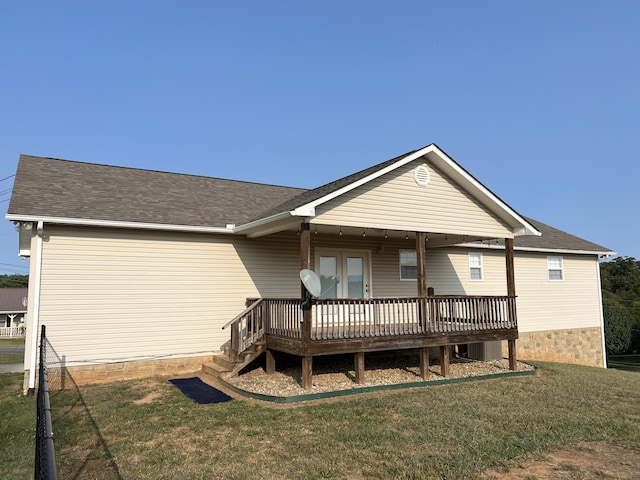 rear view of property featuring a lawn, french doors, cooling unit, and a deck