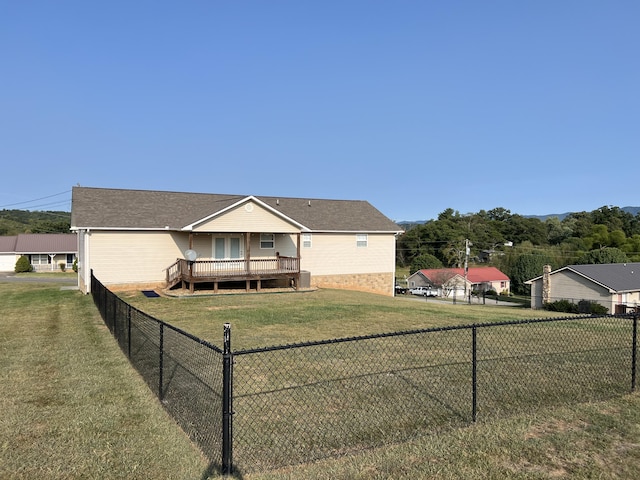 rear view of house featuring a lawn and a wooden deck