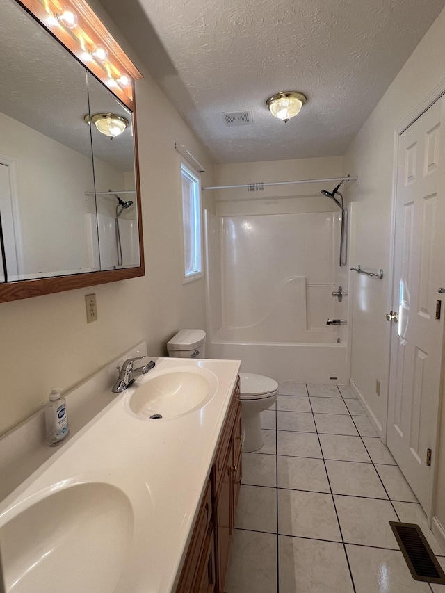 full bathroom featuring vanity, bathtub / shower combination, tile patterned floors, toilet, and a textured ceiling