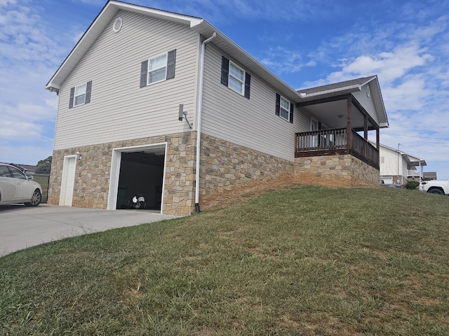 view of side of home with a garage, a yard, and a balcony