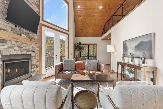 living room featuring french doors, a high ceiling, hardwood / wood-style floors, a fireplace, and wood ceiling