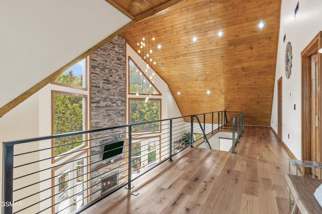 hall featuring light hardwood / wood-style flooring, high vaulted ceiling, and wooden ceiling