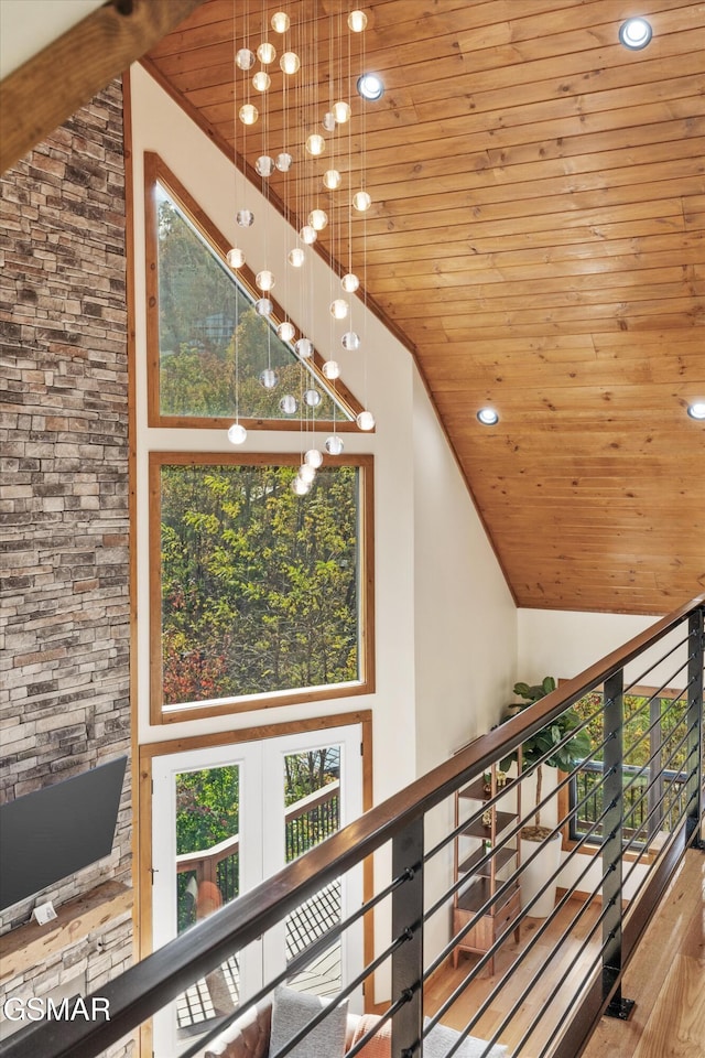 hallway with light hardwood / wood-style flooring, high vaulted ceiling, and wooden ceiling