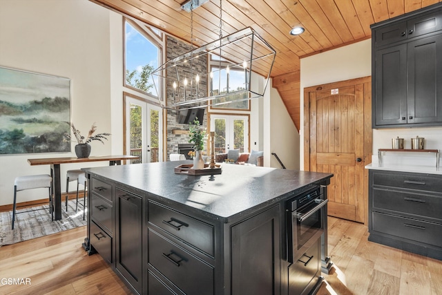 kitchen featuring french doors, a center island, wood ceiling, and light wood-type flooring