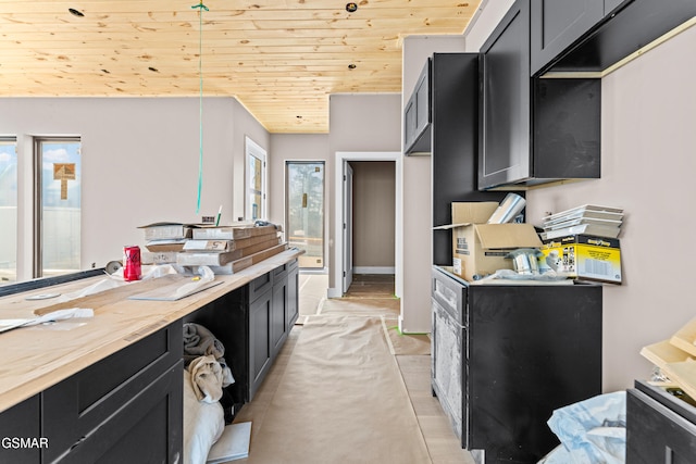 kitchen featuring lofted ceiling, wooden counters, light tile patterned floors, and wooden ceiling