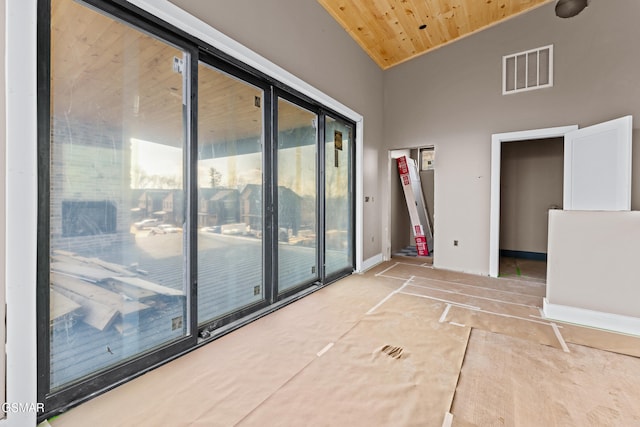 empty room with wood ceiling and high vaulted ceiling