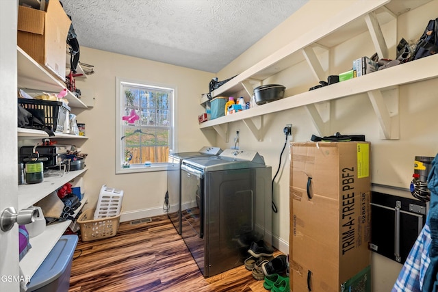 laundry room featuring laundry area, wood finished floors, baseboards, washer and clothes dryer, and a textured ceiling