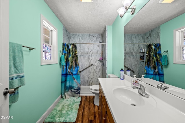 bathroom with vanity, wood finished floors, toilet, a textured ceiling, and a shower with curtain