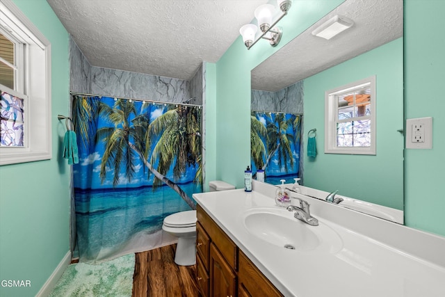 bathroom featuring vanity, toilet, a textured ceiling, shower / bathtub combination with curtain, and baseboards