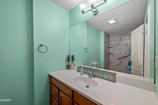 bathroom featuring vanity, a textured ceiling, a shower, and toilet