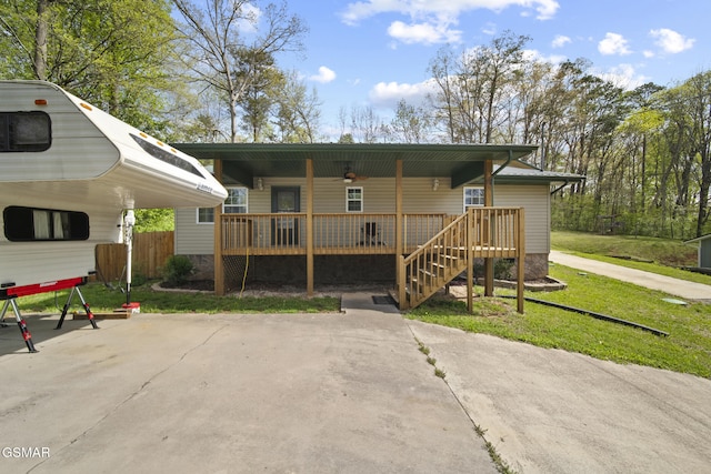 exterior space with stairway, ceiling fan, fence, and a front lawn